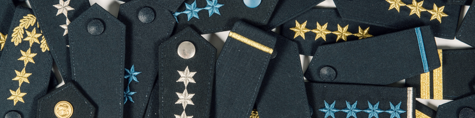 Nahaufnahme von Schulterklappen mit verschiedenen Dienstgraden der Bundespolizei. Text: 