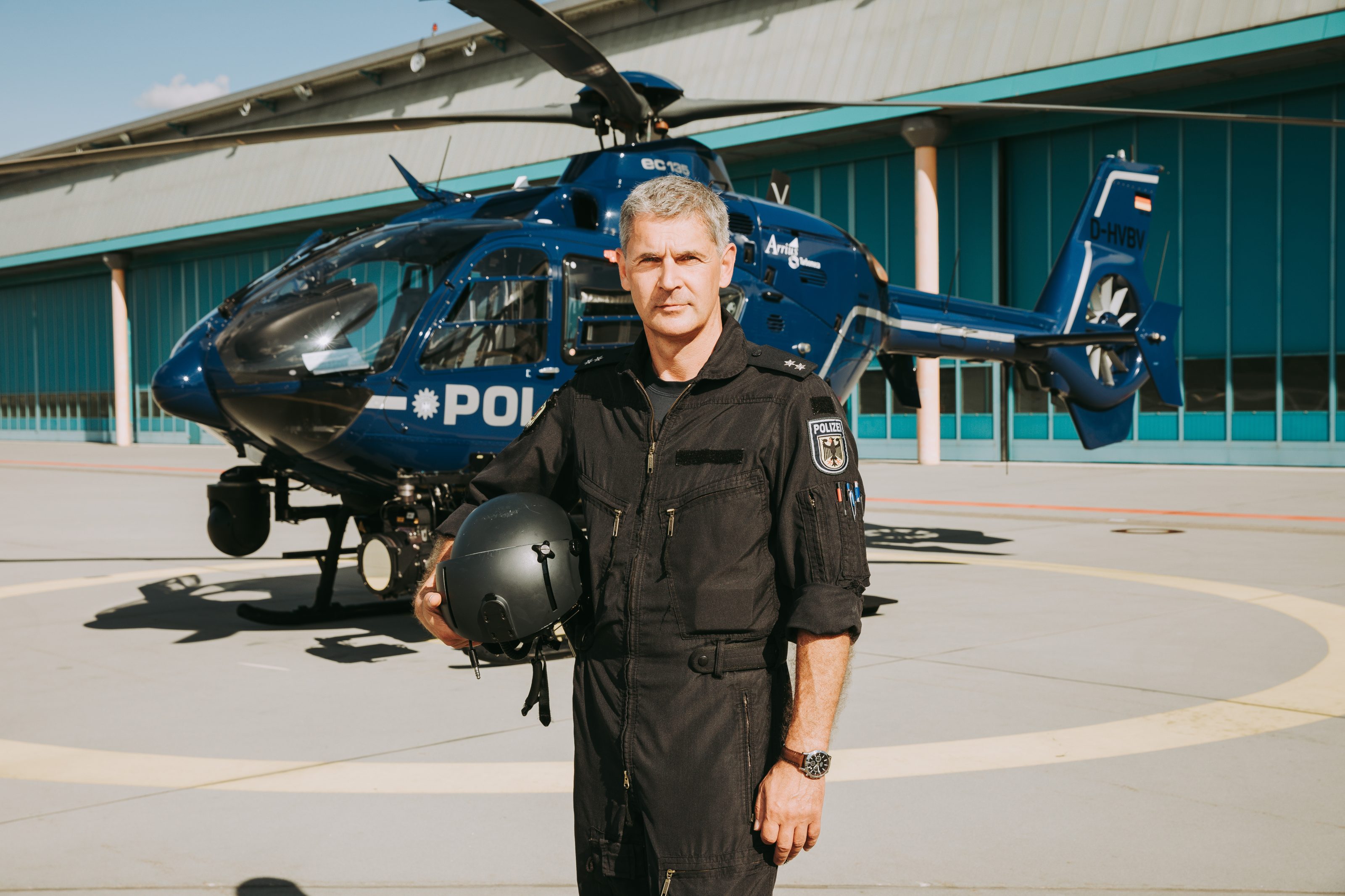 Bundespolizist mit Helm vor seinem Helikopter
